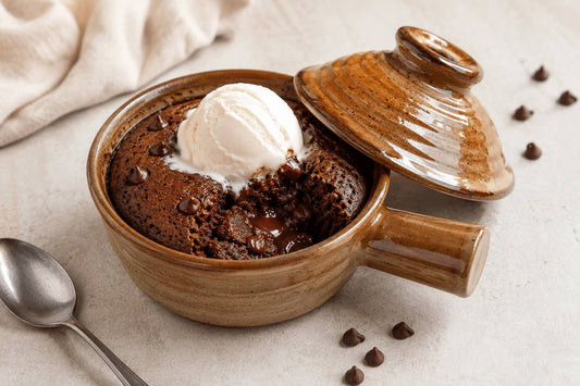 Microwave chocolate souffle in a ceramic cooker topped with whipped cream.
